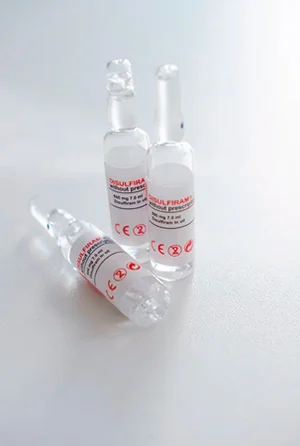 Ампулы с лекарством стоят на белом столе